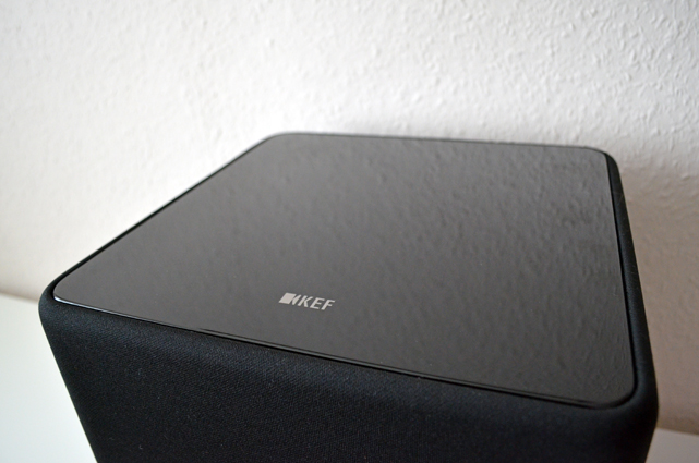 Der Subwoofer ist an den Seiten komplett mit schwarzem Stoff bespannt. Nur die Oberseite ist in hochglänzendem Schwarz lackiert.