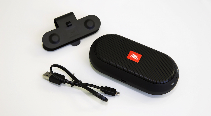 Zum Lieferumfang gehören der JBL Trip, ein USB-Ladekabel und die universell einsetzbare Halteklammer.