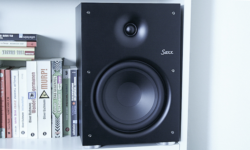 Durch ihr attraktives Design passt sich die Saxx CS 130 an nahezu jeden Ort in den eigenen vier Wänden an. Auf den Schreibtisch, dem TV-Board oder – wie hier – einfach neben den Büchern im Regal.