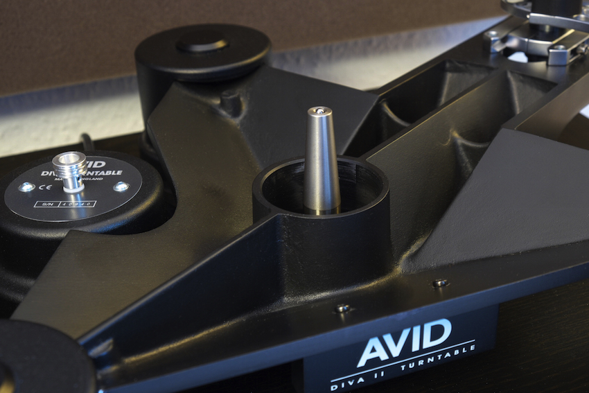 Das pfeilförmige Subchassis mit dem massiven, eingepressten Lagerdorn ist das Herzstück eines jeden AVID-Plattenspielers. Im Hintergrund ausserdem gut zu erkennen: Das Motor-Pulley für den Doppelriemen-Antrieb des DIVA 2 SP, einer der wichtigen Unterschiede zum kleineren Modell.