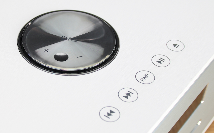 Die Lautstärkejustage erfolgt beispielsweise über den oberseitig platzierten Drehregler. Mittels Knopfdruck lässt sich das Gerät hier auch ein- und ausschalten.