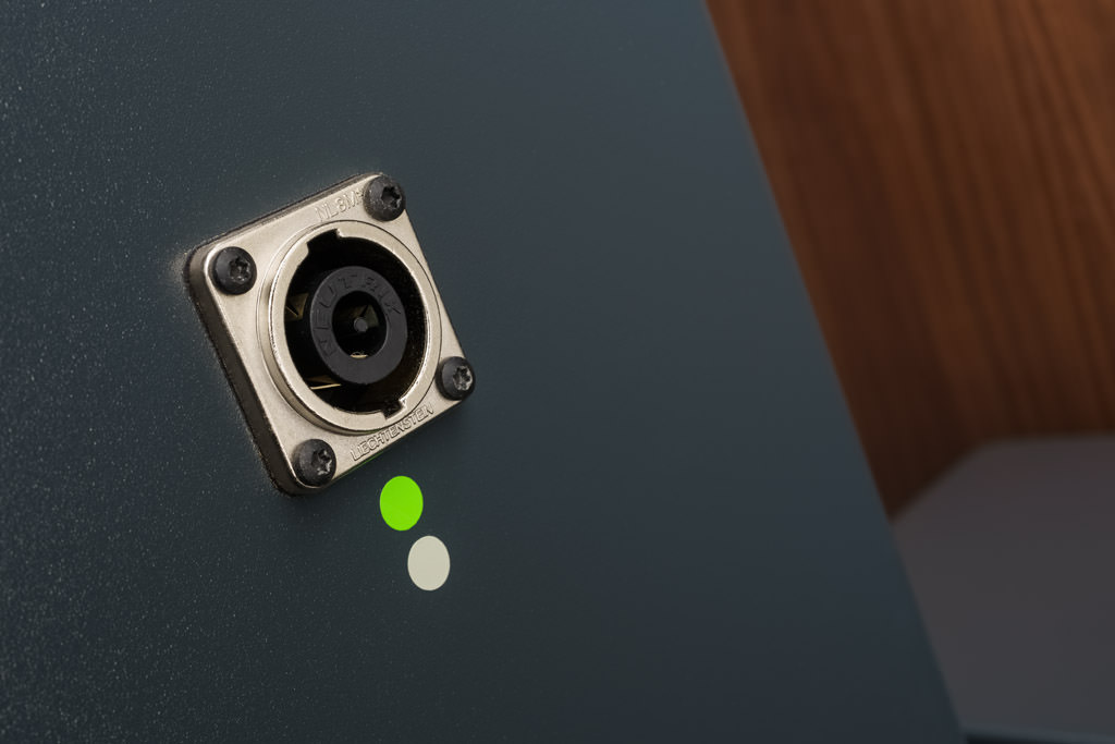 Die Standlautsprecher bieten als Anschluss eine Speakon-Buchse. Diese Lautsprecher-Verbindung bietet einige Pluspunkte: Man benötigt nur einen Stecker, somit gibt es keine Verpolungsgefahr. Stecker und Buchse sind zudem mechanisch stärker belastbar und haben überdies eine größere Kontaktfläche. Deshalb ist Speakon in der professionellen Beschallungs- und Tontechnik verbreitet. Mittlerweile hält der Standard auch im HiFi-Bereich Einzug.