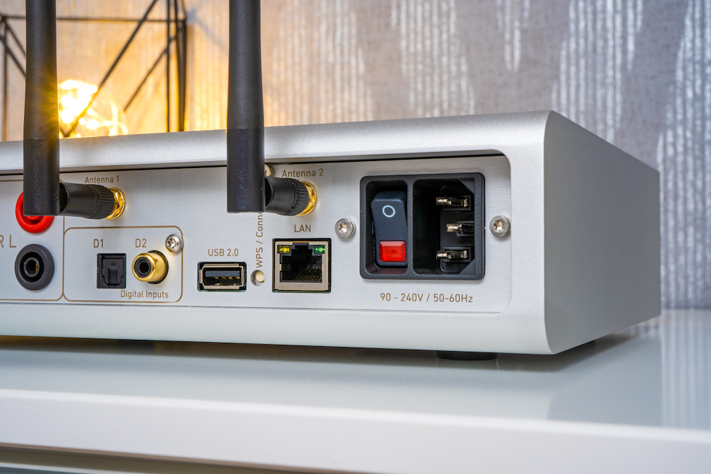 Die digitale Abteilung bietet an physischen Schnittstellen USB, LAN, SPDIF elektrisch (Coax) und SPDIF optisch (TOSLink) Als kabellose Streaming-Wege bietet der All-in-One-Player WLAN und Bluetooth. Dementsprechend sind für den Empfang zwei bewegliche Antennen eingeschraubt.