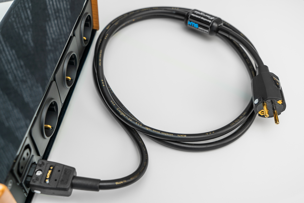 Zur RC 3/1 MK II wie auch zur RC 4/3 MK II liefert HMS als Zubehör das passende Netzkabel für den Anschluss an die Wandsteckdose. Es handelt sich bei diesem zwei Meter langen Kabel um das HMS Energia SL/V, das bereits einen Überspannungsschutz integriert hat: Der Protektor steckt in der „Pille“. Wie alle HMS-Komponenten ist auch bei diesem Kabel die Phase markiert, es sind die weißen Punkte an den Steckern.