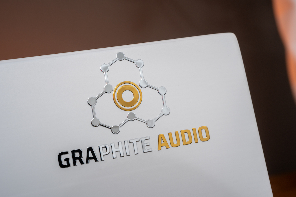 Das Logo ist der hexagonalen Kristallstruktur von Graphit nachempfunden – also jenem Mineral, das Graphite Audio maßgeblich zur Performance-Steigerung seiner Produkte einsetzt.