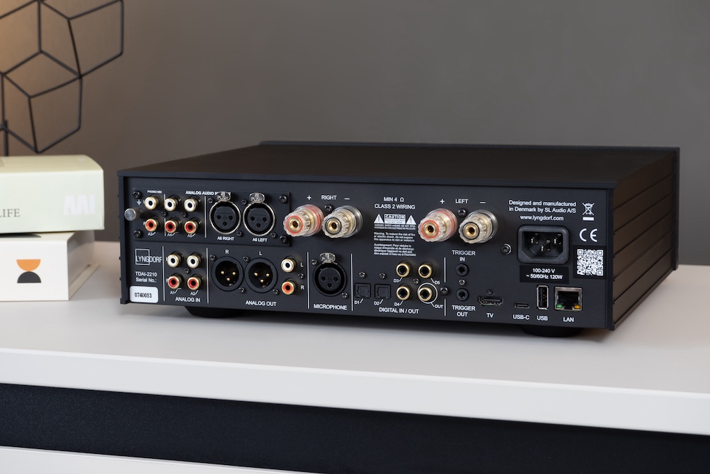 Pralles Portfolio: Rückseitig bietet der TDAI-2210 zahlreiche und vielseitige analoge sowie digitale Anschlussmöglichkeiten und Schnittstellen. Das links oben eingesetzte Analog-Modul ist allerdings eine Upgrade-Option, die die Grundversion nicht bietet. Der „Micophone“-XLR-Input ist für den Anschluss des Einmessmikrofons vorgesehen. Trotz WiFi und Bluetooth ist der Verstärker frei von sichtbaren Antennen: Sie sind unauffällig in das Areal der Glasscheibe integriert.