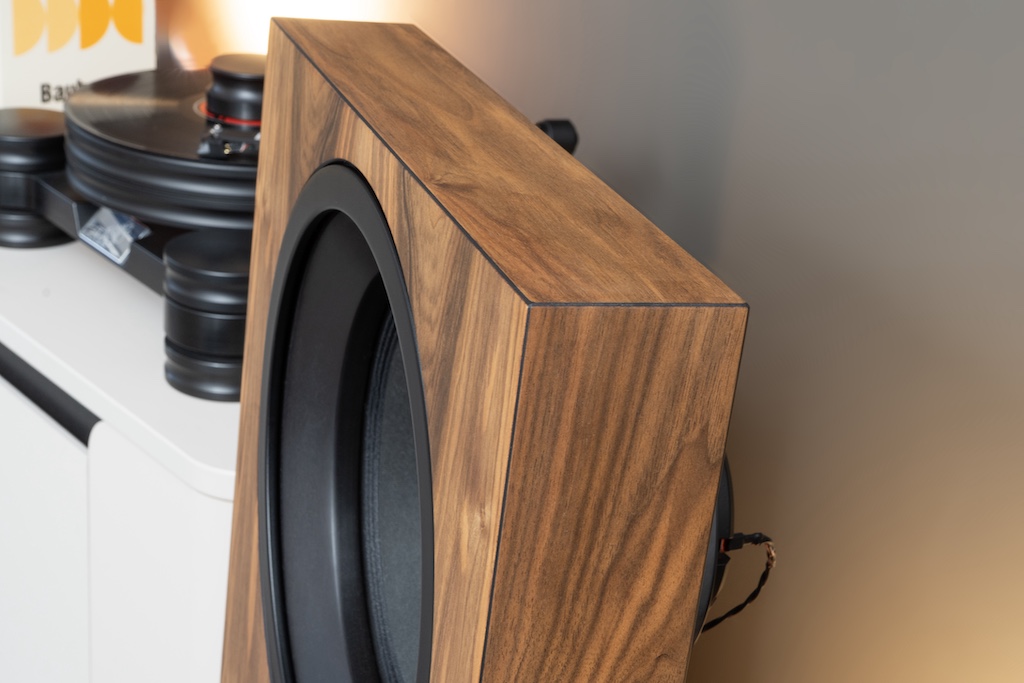 Edle Optik: Die No.5 präsentiert sich hier im attraktiven Nussbaum-Echtholzfurnier. Das Holz ist naturbelassen, die Oberfläche ausschließlich geölt, was die aparte Maserung hervorhebt. Die Holzflächen sind an allen Kanten leicht gefast und schwarz abgesetzt. Dieser markante Kontrast korrespondiert auch mit den ebenfalls schwarzen Chassis-Einfassungen.