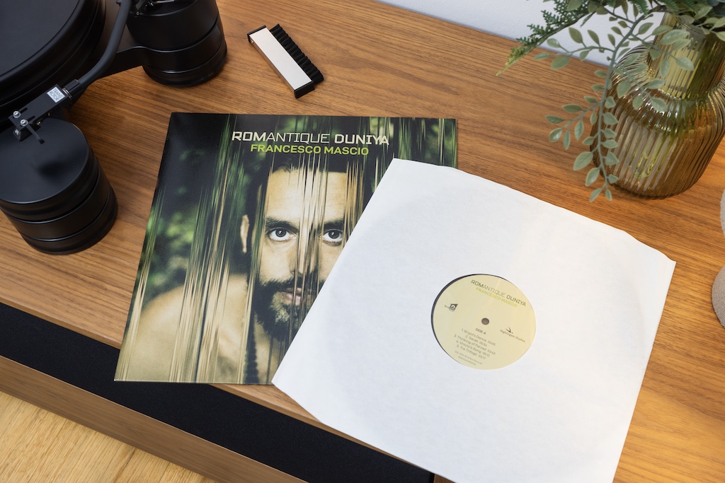 Das Vinyl steckt in einer papiernen Innenhüllen, die innseitig mit einer antistatischen Folie gefüttert ist. Die Platte gleitet geschmeidig und ohne Staub anzuziehen aus der Hülle.