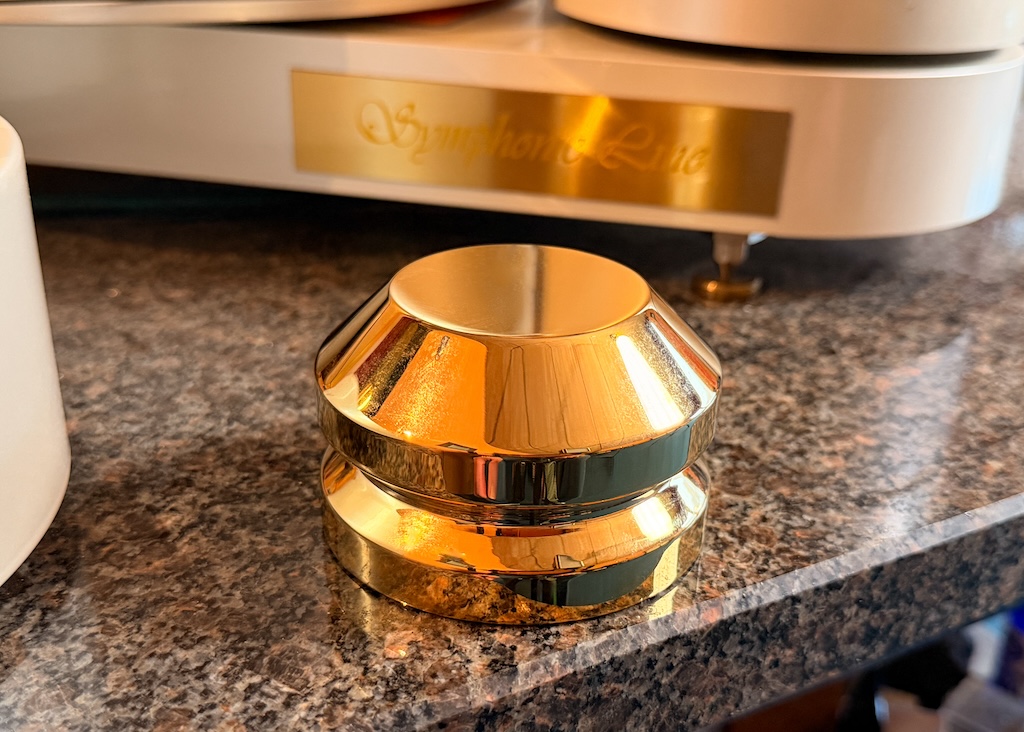 Imposanter Beschwerer: Ein vergoldeter Puck sorgt mit rund 800 Gramm Gewicht dafür, dass die Schallplatte auf den Teller gepresst wird.