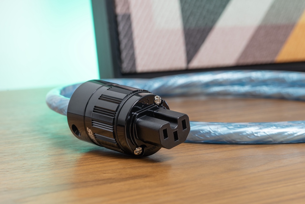 Für den Anschluss an die Komponente ist das Kabel mit einer Kaltgerätekupplung vom Typ IEC 60320 C15 ausgestattet. Das Gehäuse zeichnet sich durch sehr gute Griffigkeit aus, die Metallteile glänzen mit einer Beschichtung aus Rhodium. Alternativ ist das Kabel auch mit der noch höher belastbaren Kaltgerätekupplung IEC320 C19 erhältlich, sie ist statt bis 10 Ampere bis 16 Ampere ausgelegt.