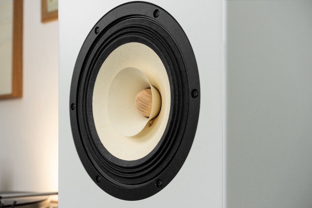 Der besondere Blickfang ist der Schwirrkonus: Dieser Kegel, der auf die Hauptmembran aufgesetzt ist, befördert die Wiedergabe der Höhen. Ihre Abstrahlung ist auch durch den zentralen Phase Plug veränderbar. Hier ist er in seiner natürlichen Holzoptik belassen, er kann aber in jeder gewünschten Farbe lackiert werden.