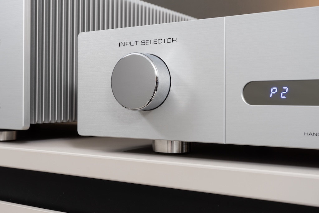Mit dem „Input Selector“ wählt man durch Drehen den gewünschten Eingang aus. Durch Drücken dieses verchromten massiven Messing-Knopfes gelangt man hingegen zum Menü: Hier ist der Vorverstärker mit zahlreiche Einstellungen anpassbar.